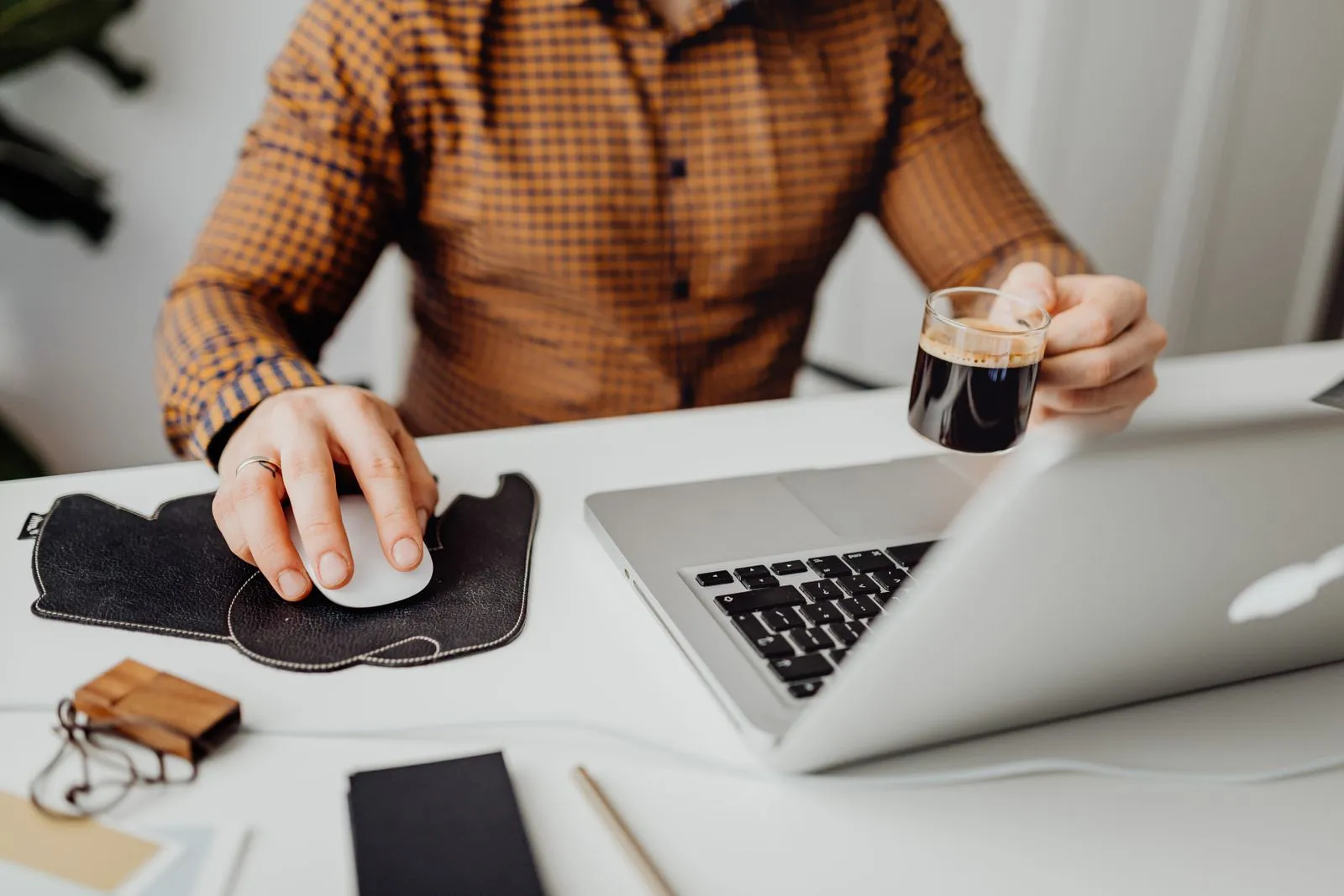 A person working from home at a laptop with a cup of coffee nearby
